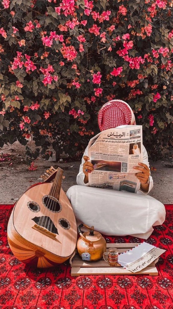 Mann som leser arabisk av sittende på orientalsk teppe.