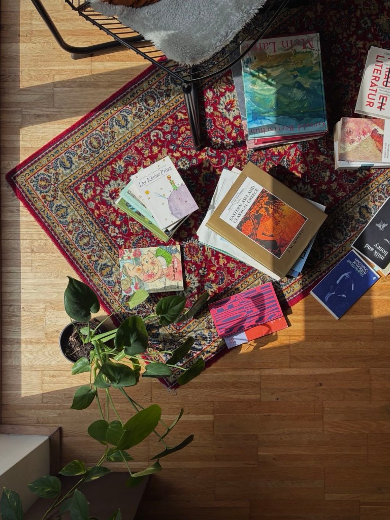 Et hjem med orientalsk teppe, bøker og plante.