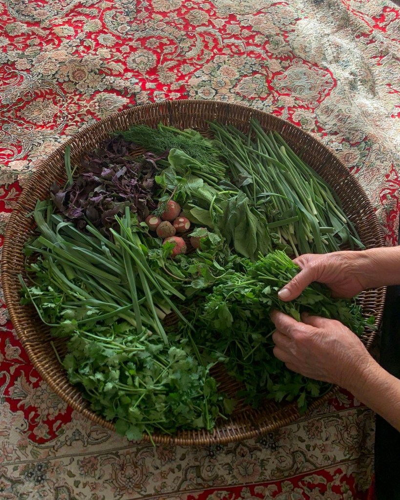 Grønnsaker og gress vaskes og ordnes sittende på teppet.