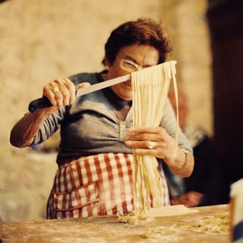 Italiensk dame som lager pasta fra bunnen.