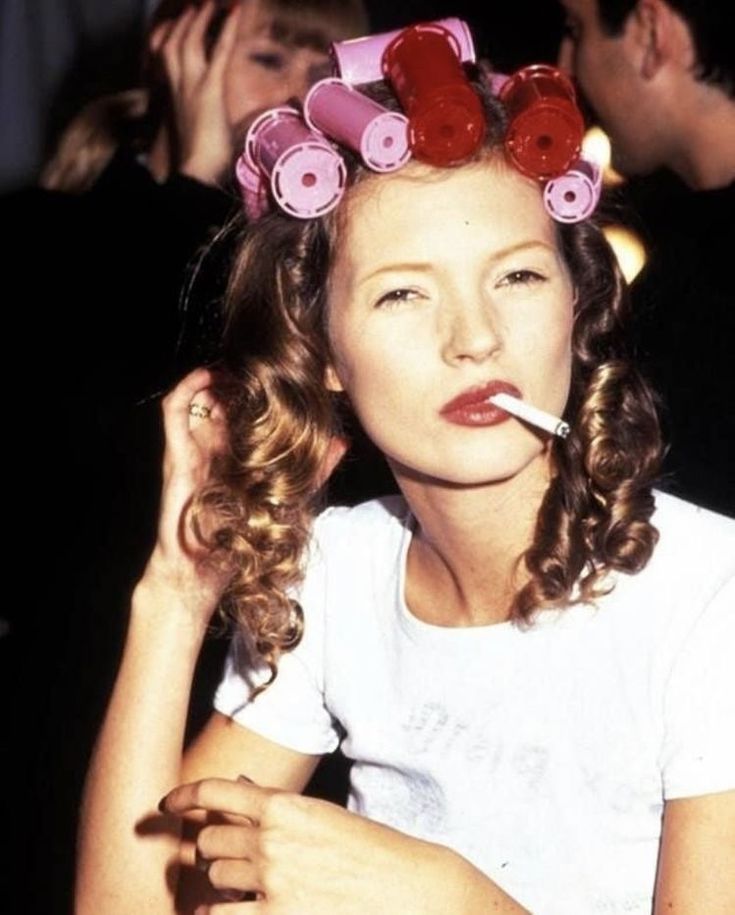 Supermodell Kate Moss avbildet med hårruller og sigarett på 90-tallet.