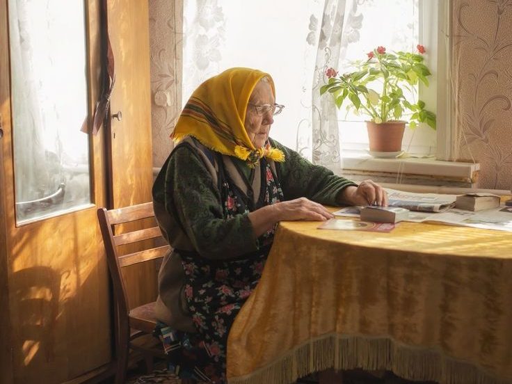 Gammel dame ibabushka på kjøkkenet.