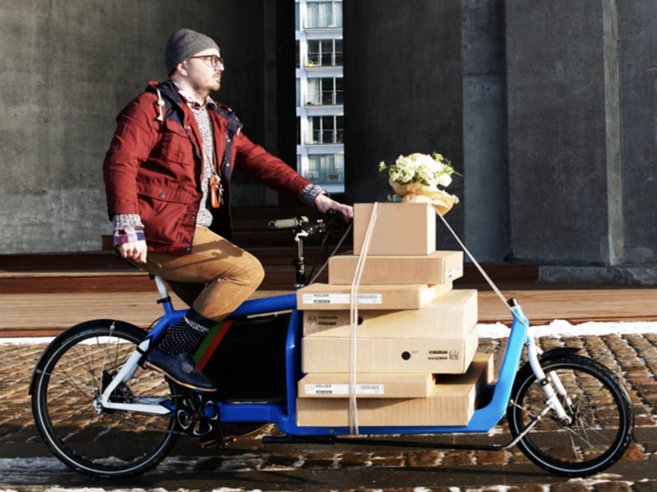 Mann på sykkel med flatpakker. 