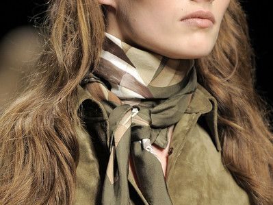 Dame i khaki-skjorte og skjerf. 