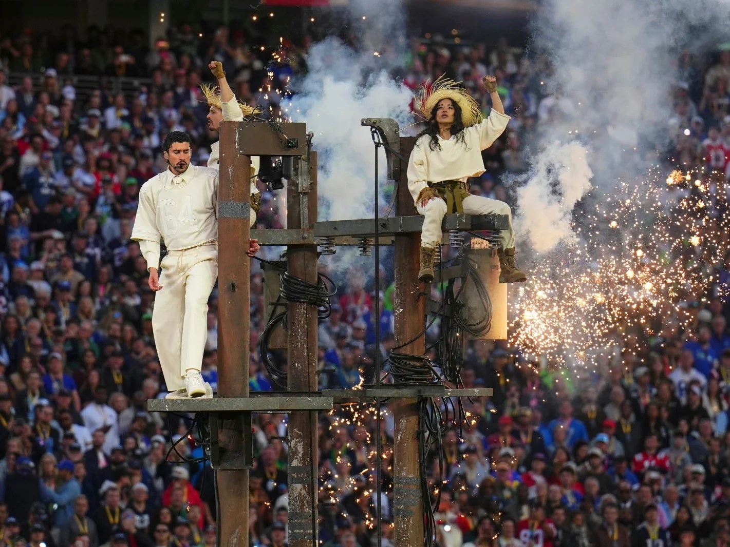 Bad Bunny står på lyktestolpe sammen med danserne som har på seg stråhatter.