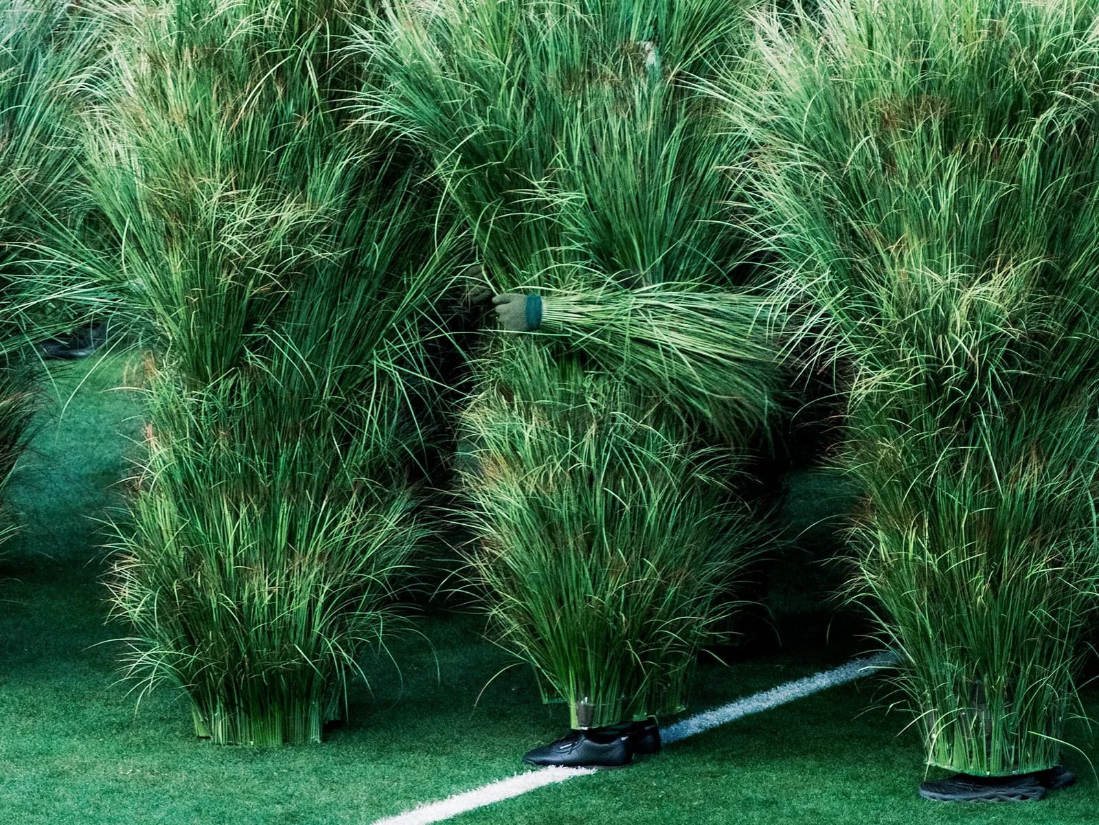 Mennesker i gress-kostymer. 